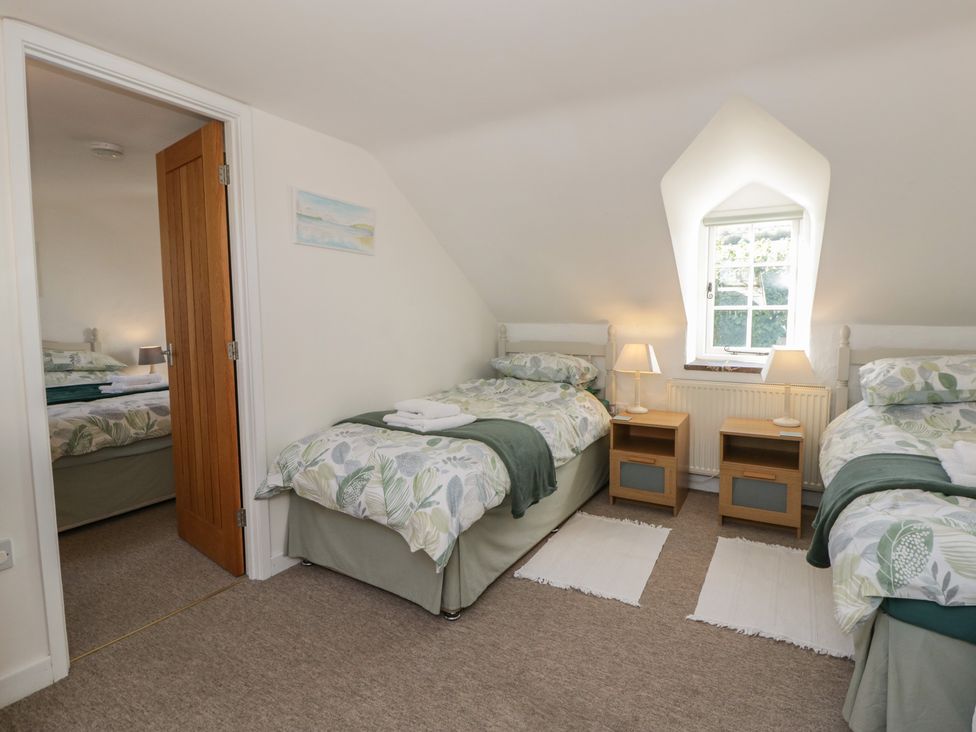 A bedroom with two single beds and bedside tables at End Cottage in Newport, Pembrokeshire