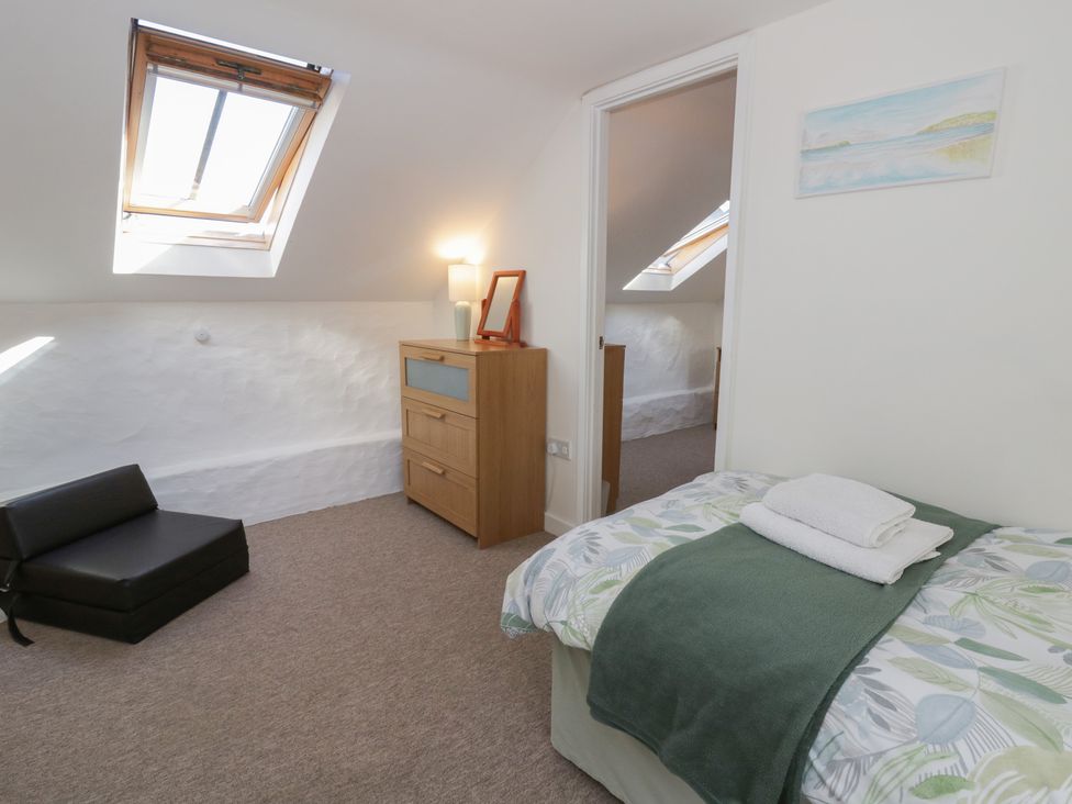 A bedroom with a bed and dresser at End Cottage Newport, Pembrokeshire