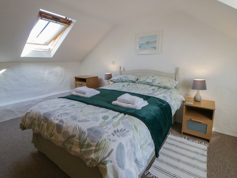 A bedroom with a bed and nightstand at End Cottage Newport, Pembrokeshire