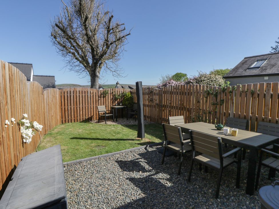 A garden with seating and a tree at End Cottage Newport, Pembrokeshire