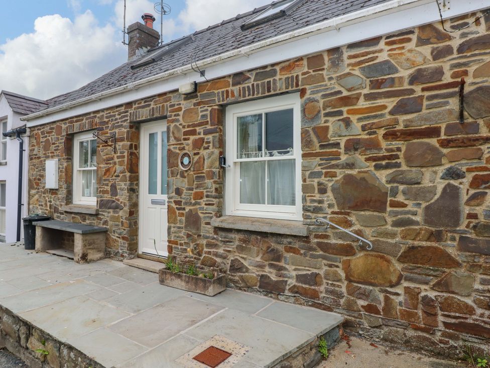 A stone wall with a door and windows at Brynawelon Newport, Pembrokeshire