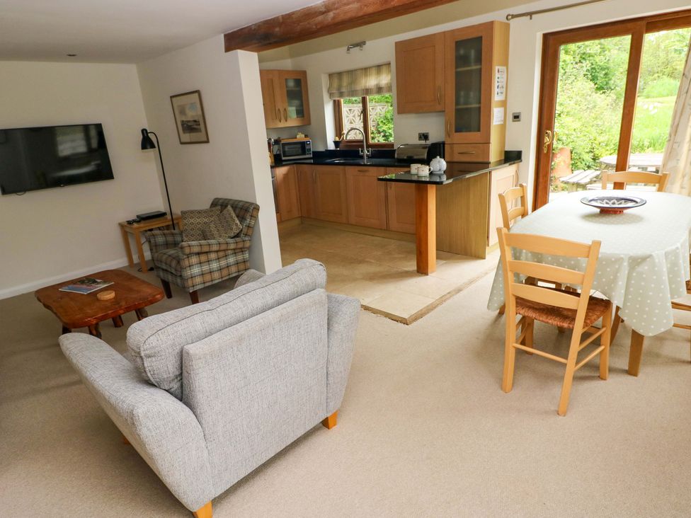 A living room with a television and dining area at Brynawelon, Newport, Pembrokeshire
