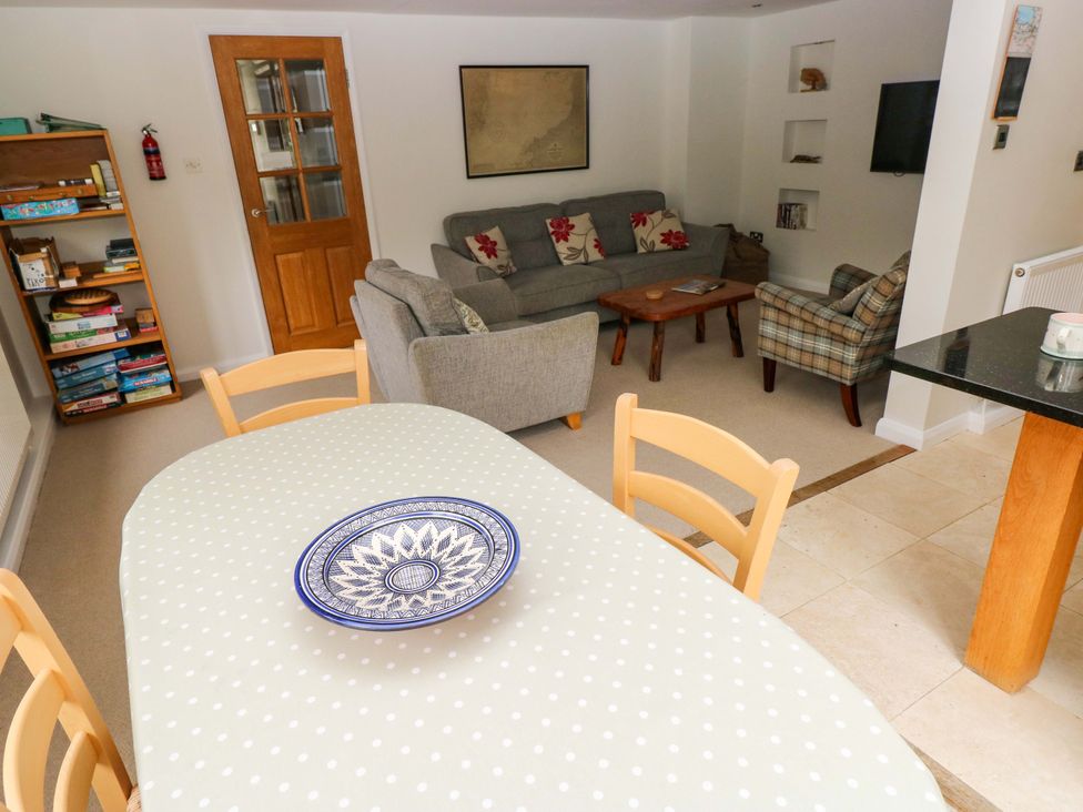 A dining room featuring a table with a patterned cloth and a sofa at Brynawelon Newport, Pembrokeshire