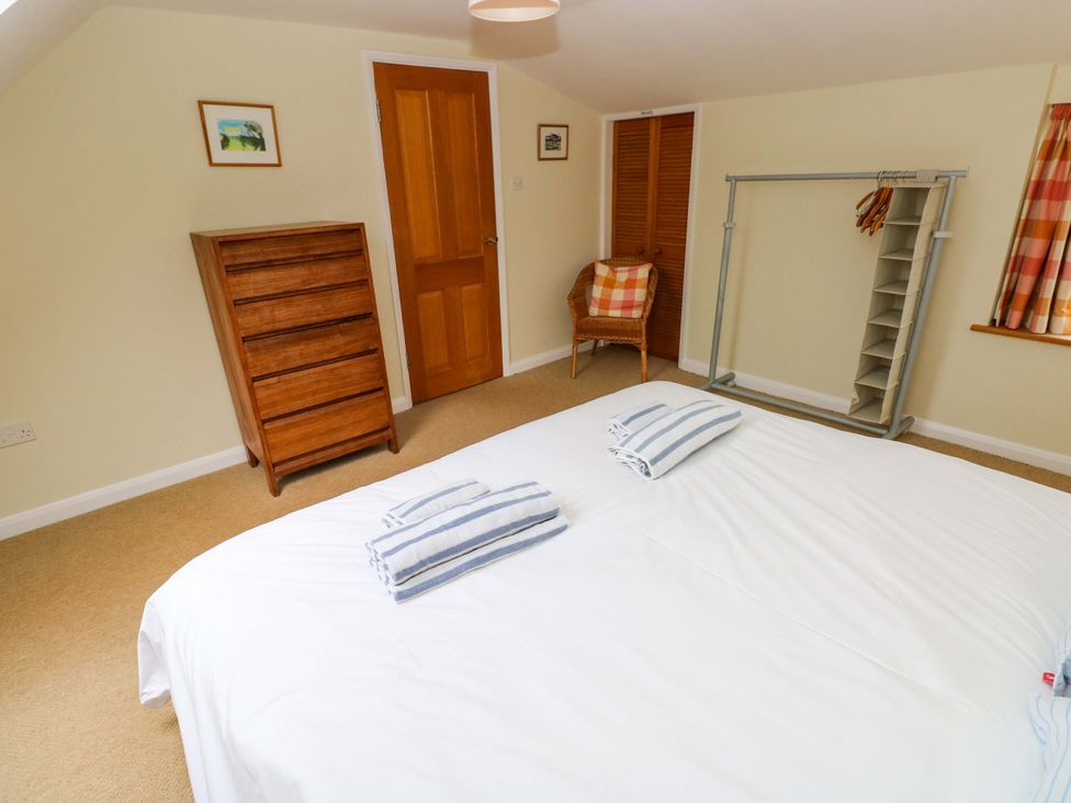 A bedroom with a double bed and furniture at Brynawelon Newport, Pembrokeshire