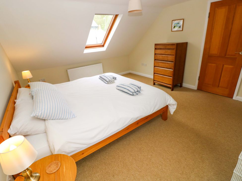 A bedroom with a bed and dresser at Brynawelon in Newport, Pembrokeshire