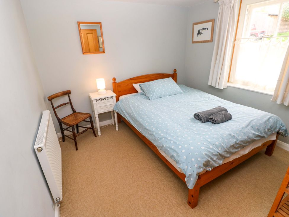 A bedroom with a bed and side table at Brynawelon Newport, Pembrokeshire