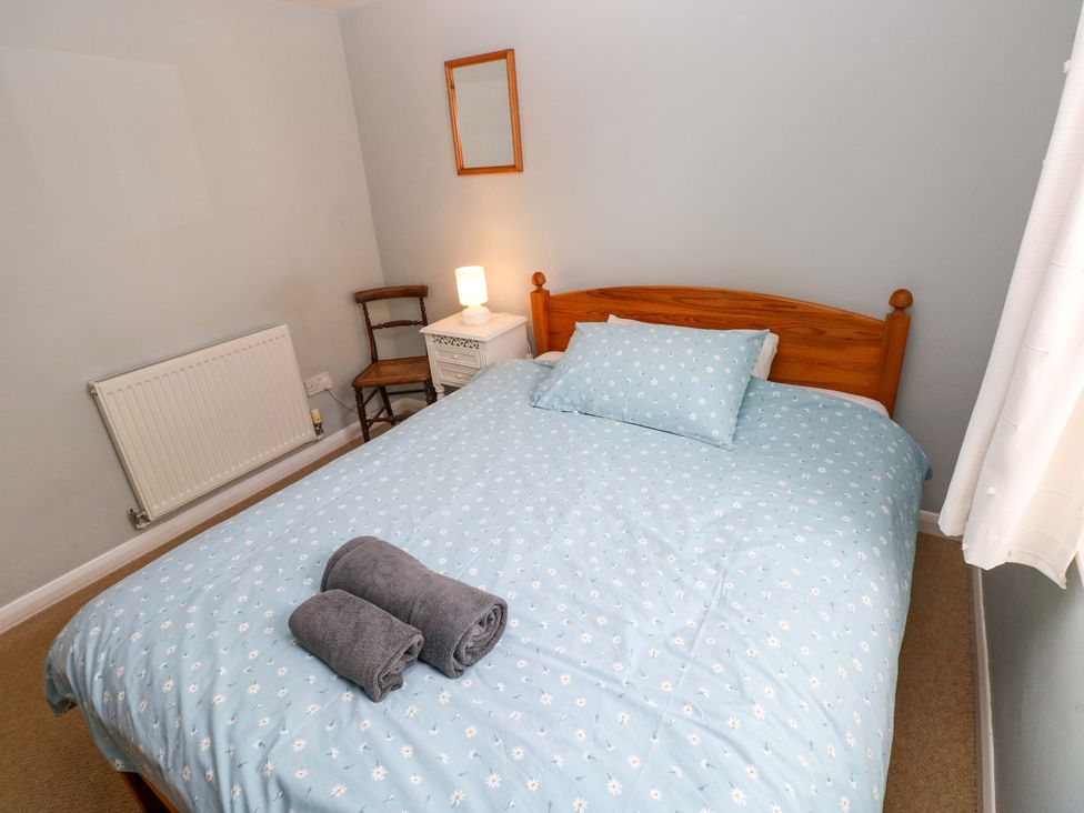 A bedroom with a bed and nightstand at Brynawelon in Newport, Pembrokeshire