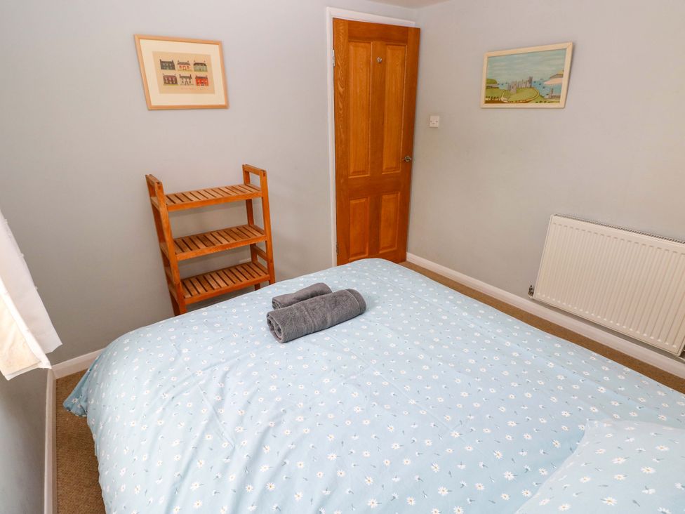 A bedroom with a bed and towels at Brynawelon in Newport, Pembrokeshire