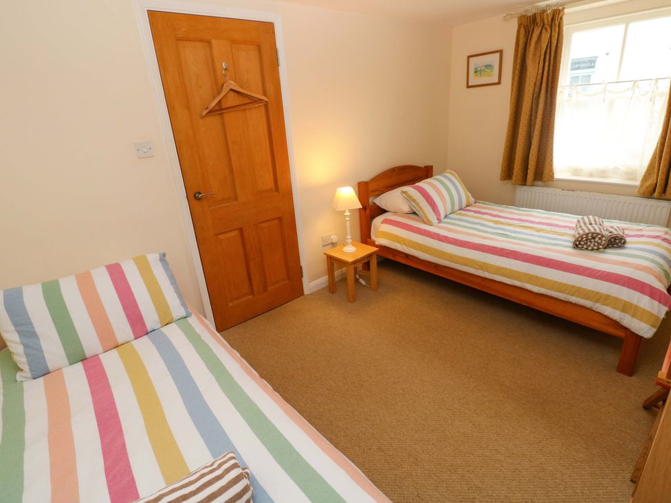 A bedroom with two beds and a lamp at Brynawelon Newport, Pembrokeshire