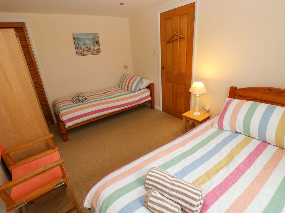 A bedroom with two beds and a wardrobe at Brynawelon in Newport, Pembrokeshire