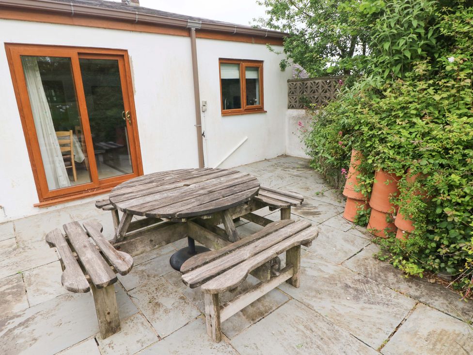 A garden with a wooden table and benches at Brynawelon in Newport, Pembrokeshire