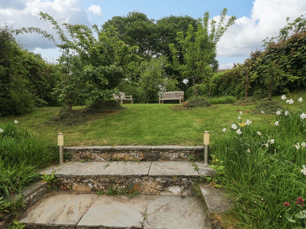 A garden with a bench and trees at Brynawelon Newport, Pembrokeshire