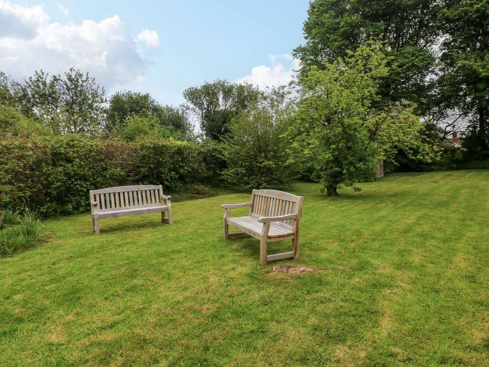 Two wooden benches in a garden at Brynawelon Newport, Pembrokeshire