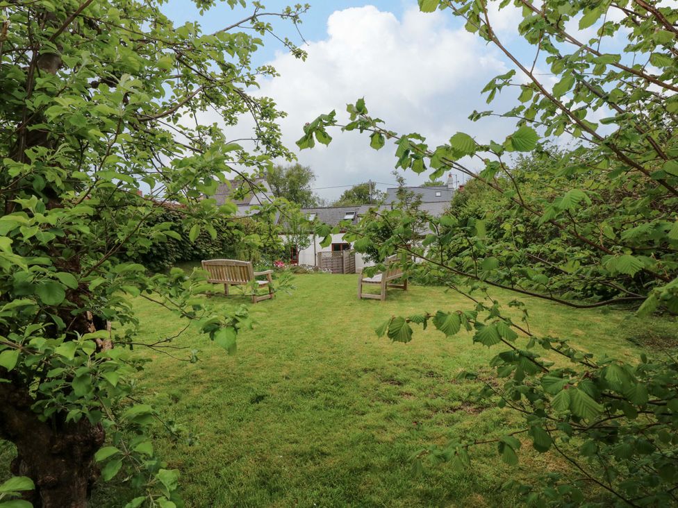 A garden with grass and seating at Brynawelon Newport, Pembrokeshire