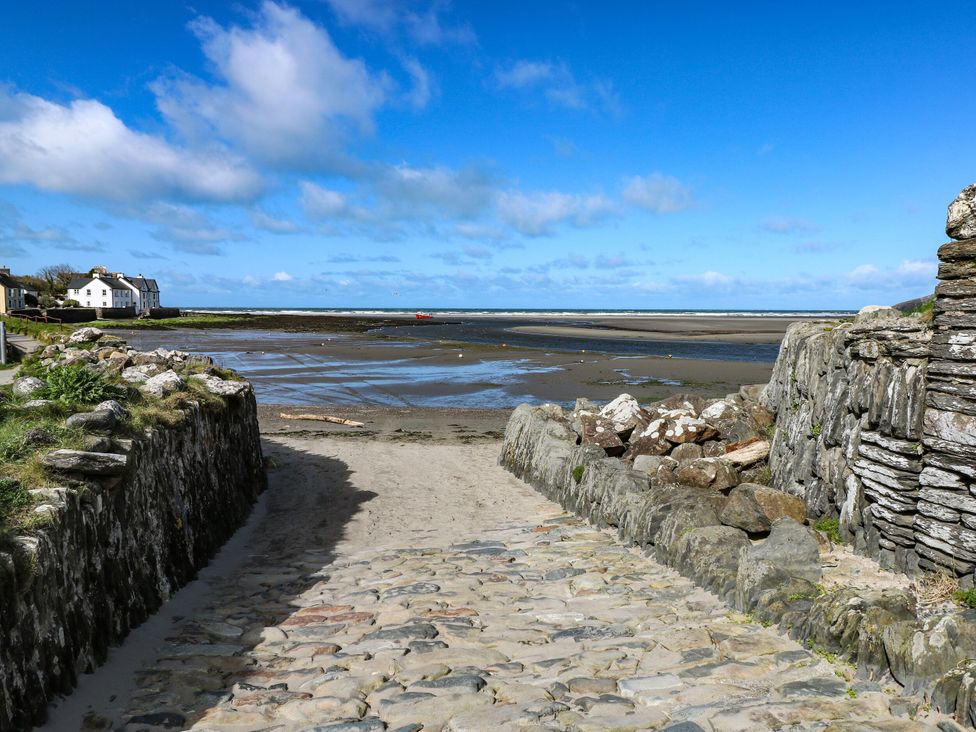 A pathway leading to a beach with sea and houses at Brynawelon Newport, Pembrokeshire