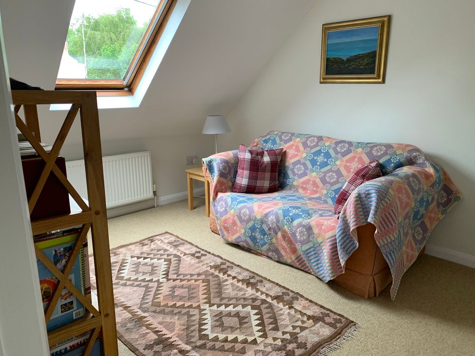 A snug with a sofa and a lamp at Brynawelon in Newport, Pembrokeshire