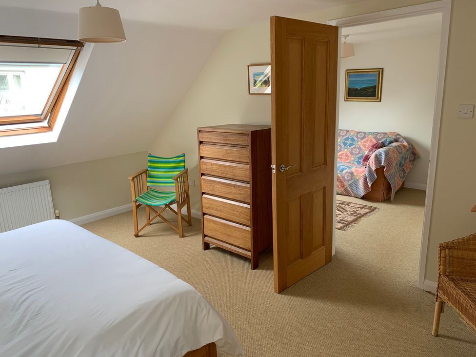 A bedroom with a bed and dresser at Brynawelon, Newport, Pembrokeshire