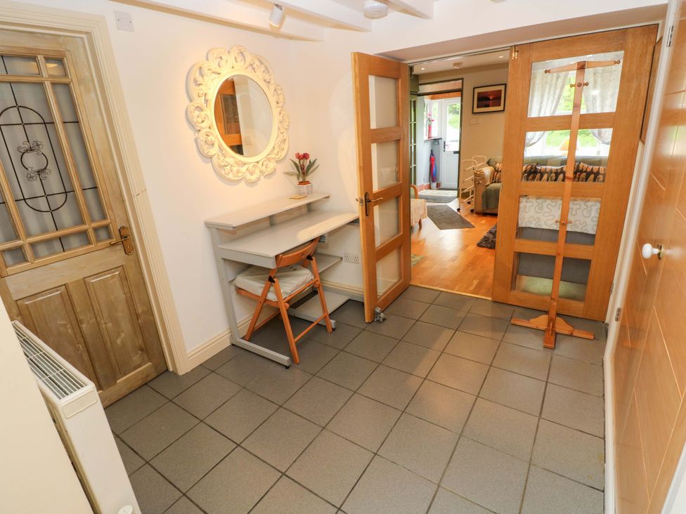 An entrance hall with a mirror and shelves at Greenbanks in Dinas Cross, Pembrokeshire