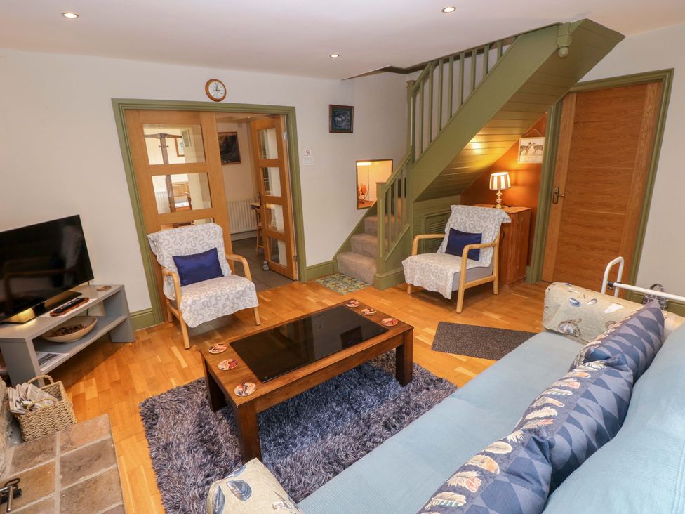 A living room with a sofa and coffee table at Greenbanks, Dinas Cross, Pembrokeshire