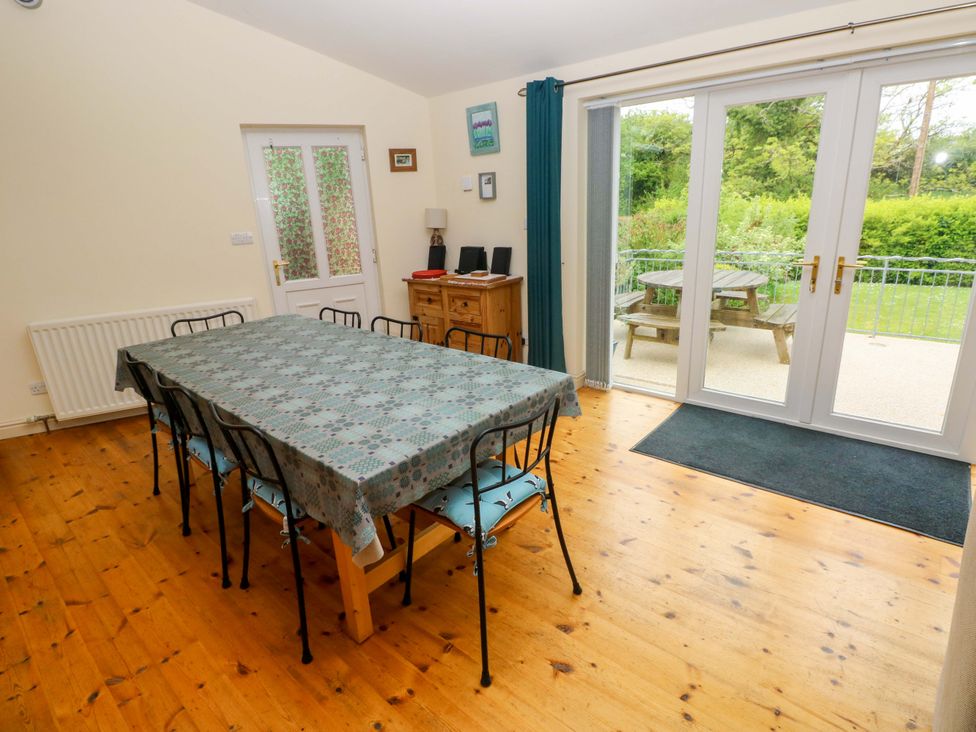 A dining room with a large table and chairs at Greenbanks Dinas Cross Pembrokeshire