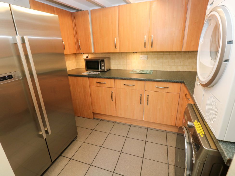 A kitchen with refrigerator and microwave at Greenbanks in Dinas Cross, Pembrokeshire