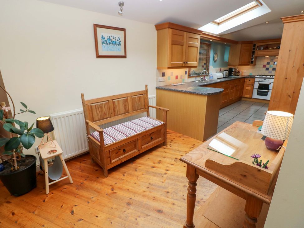 A kitchen with wooden furniture and cabinets at Greenbanks in Dinas Cross, Pembrokeshire