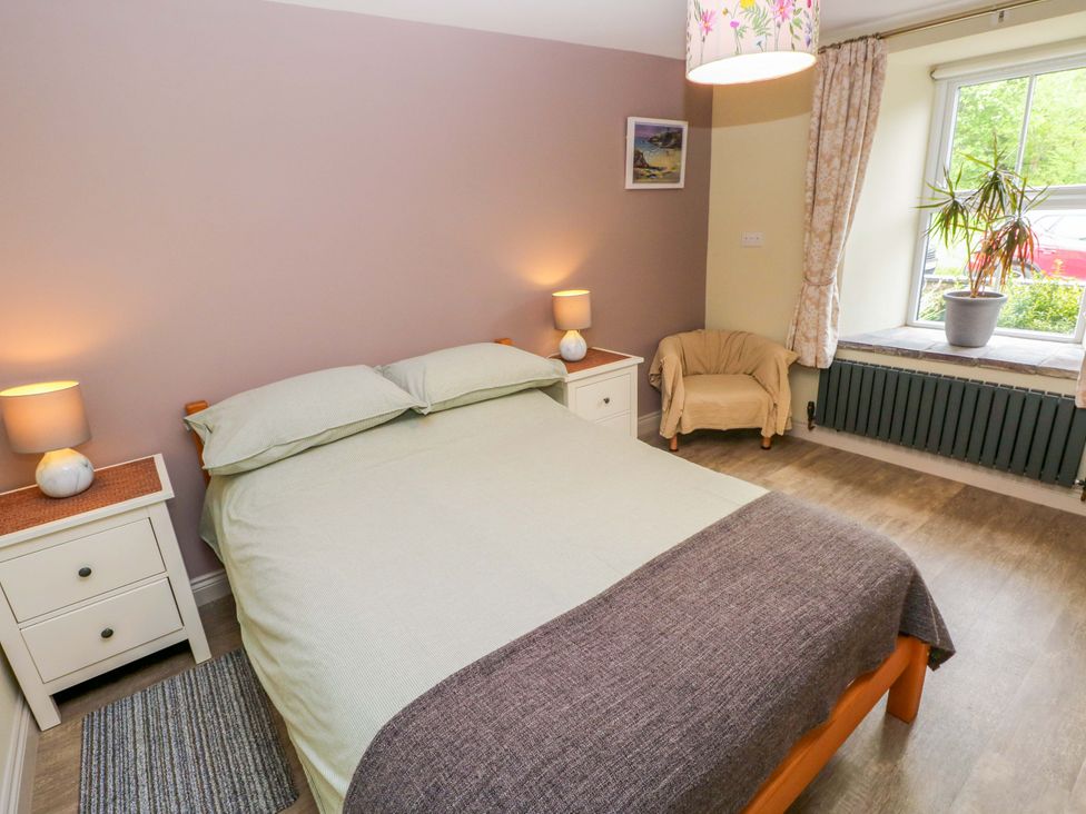 A bedroom with a bed and nightstand at Greenbanks, Dinas Cross, Pembrokeshire