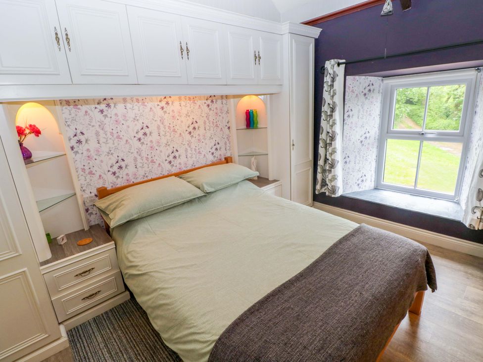 A bedroom with a bed and a window at Greenbanks in Dinas Cross, Pembrokeshire