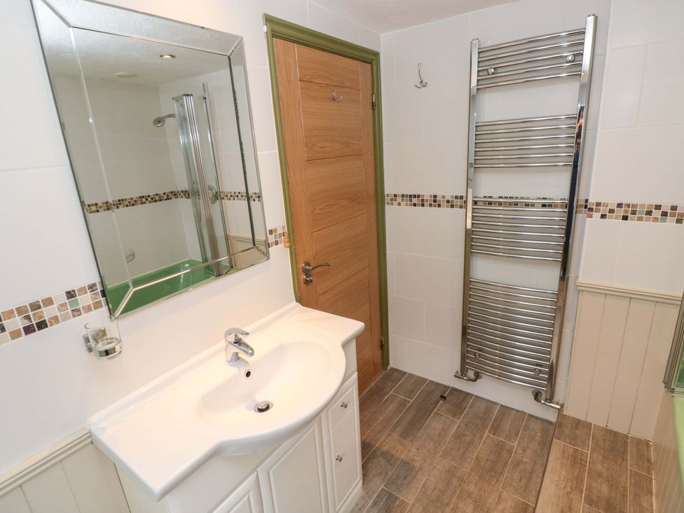 A bathroom with a sink and a shower at Greenbanks Dinas Cross, Pembrokeshire