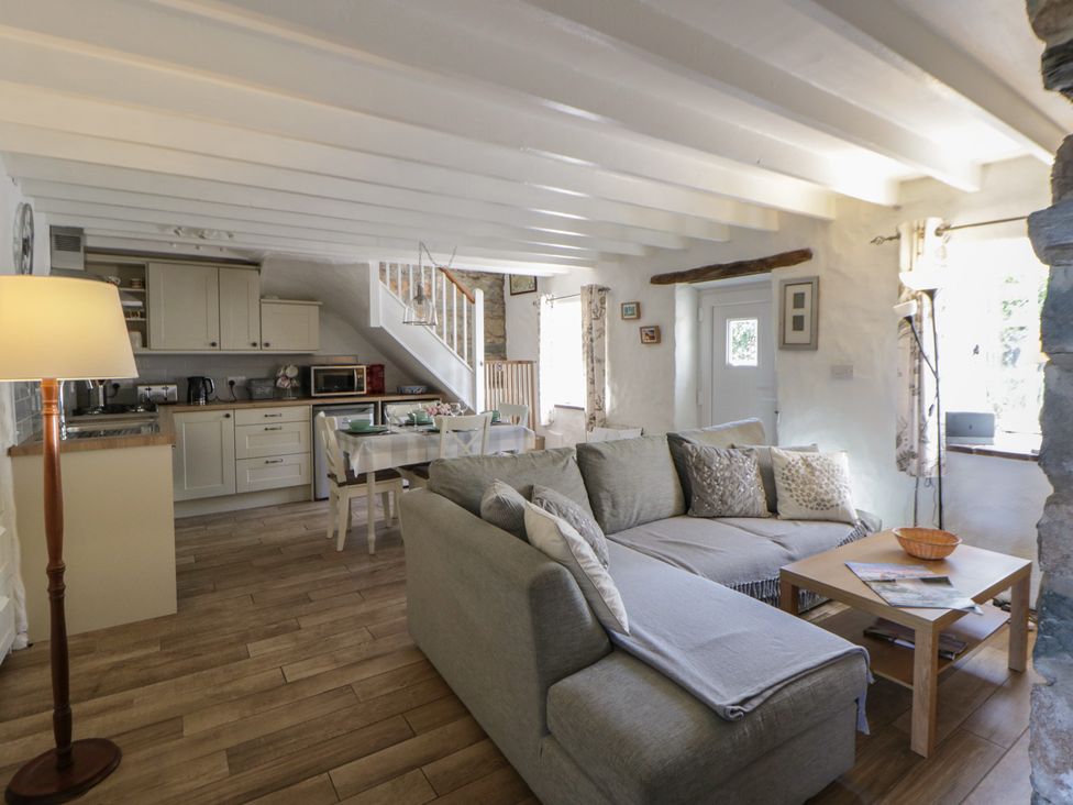 A living room with a sofa and dining area at Middle Cottage in Newport, Pembrokeshire