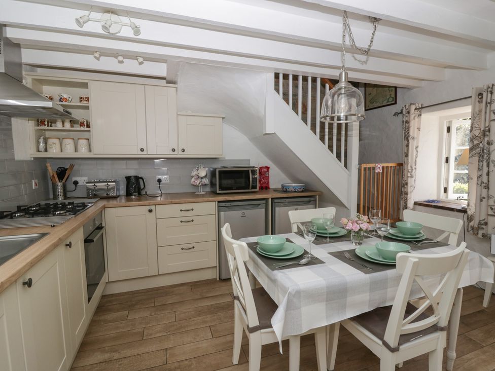 A kitchen with dining table and appliances at Middle Cottage in Newport, Pembrokeshire