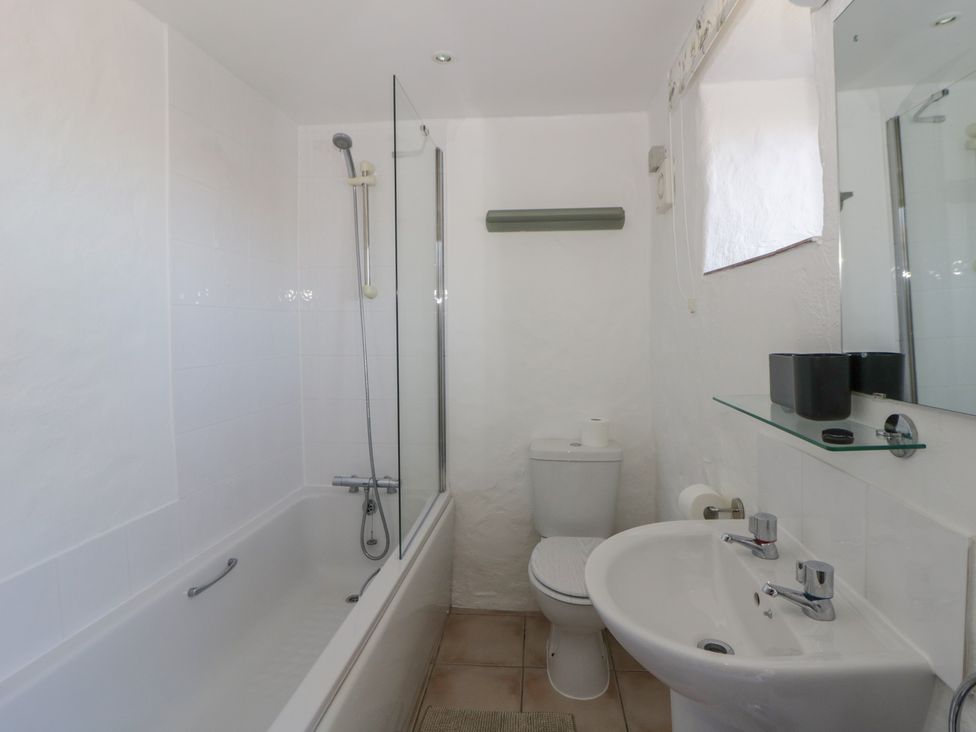 A bathroom with a bathtub, shower, toilet and sink at Middle Cottage Newport, Pembrokeshire