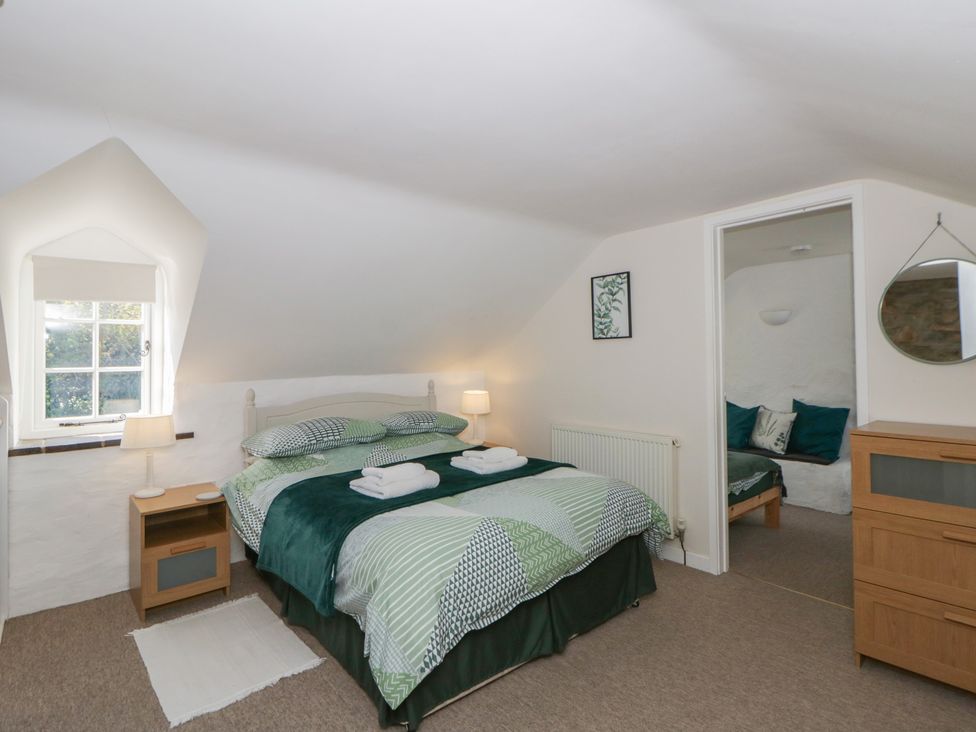 A bedroom with a bed and nightstand at Middle Cottage, Newport, Pembrokeshire