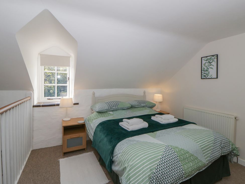 A bedroom with a bed and bedside table at Middle Cottage in Newport, Pembrokeshire