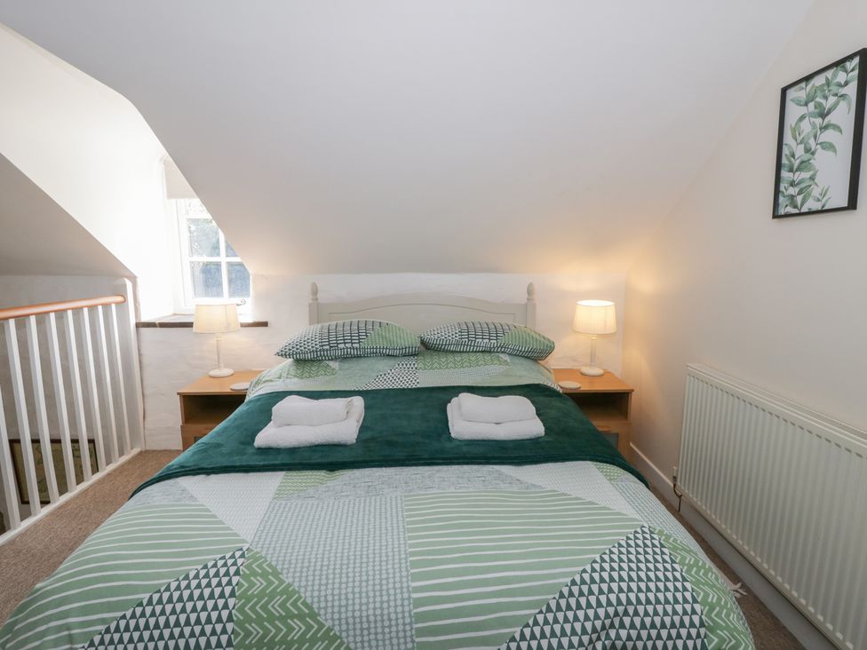 A bedroom with a bed and bedside table at Middle Cottage in Newport, Pembrokeshire