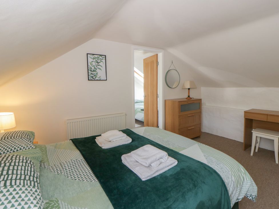 A bedroom with a bed and a lamp at Middle Cottage, Newport, Pembrokeshire