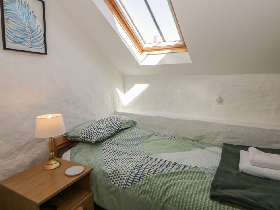 A bedroom with a bed and a lamp at Middle Cottage in Newport, Pembrokeshire