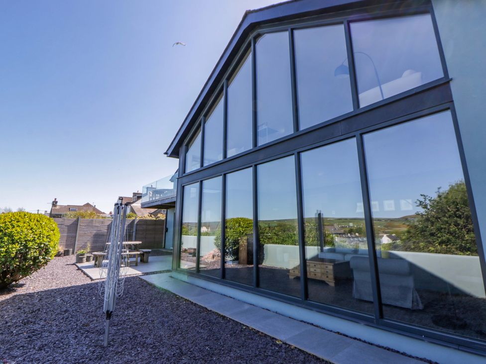 Outdoor view of a house with large windows and a garden at The Willows in Newport, Pembrokeshire