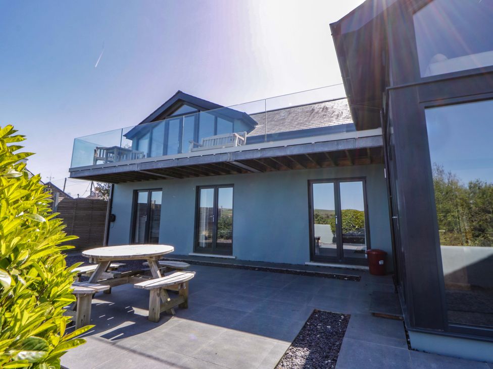 An outdoor area with a table and chairs beside a house at The Willows in Newport, Pembrokeshire