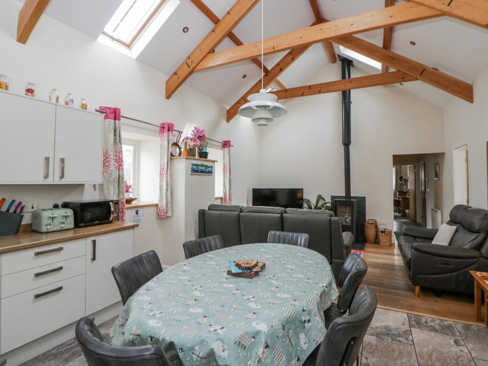 A kitchen with a dining table and seating at Y Felin Cardigan Ceredigion