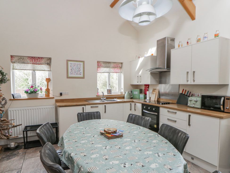 A kitchen with a round dining table and chairs at Y Felin in Cardigan, Ceredigion