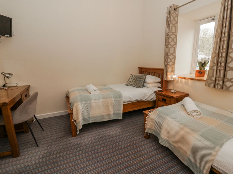 A bedroom with two beds and a desk at Y Felin Cardigan, Ceredigion