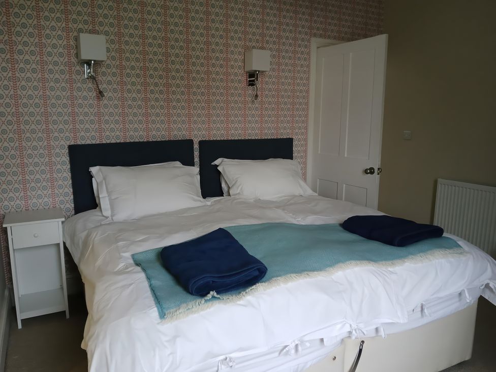 A bedroom with a bed and nightstand at Lyndale Newport, Pembrokeshire