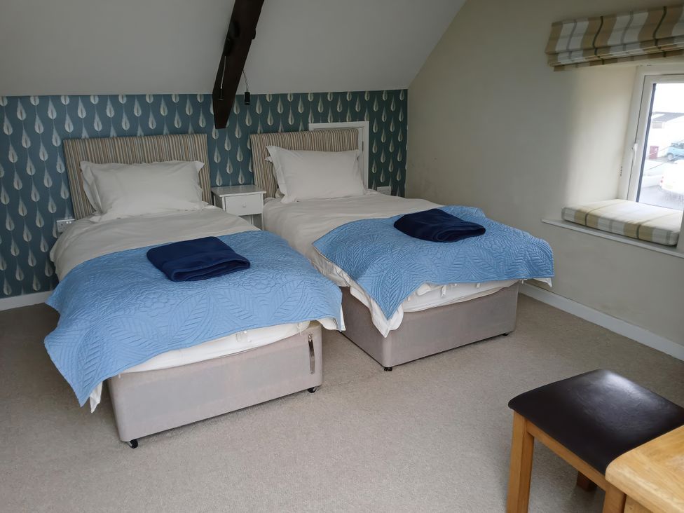 A bedroom with two single beds and a window at Lyndale in Newport, Pembrokeshire