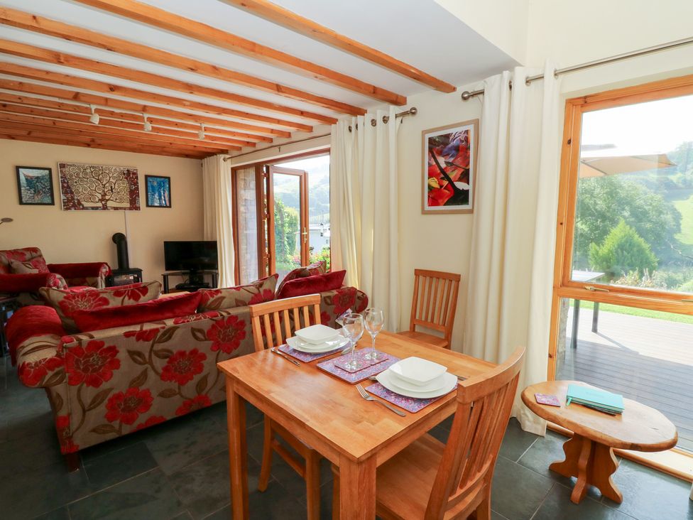 A living room with a sofa and dining area at Dan Castell Cottage in Llandeilo, Carmarthenshire