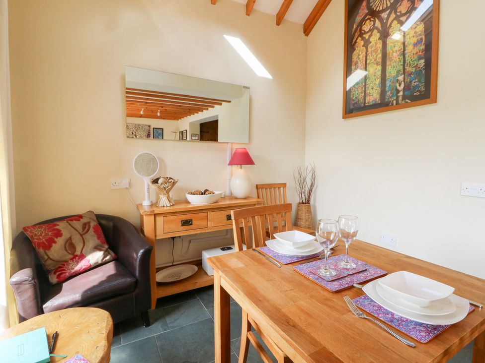 A dining room with a table set for two at Dan Castell Cottage, Llandeilo, Carmarthenshire