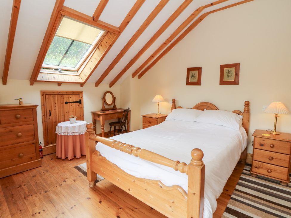 A bedroom with a bed and furniture at Dan Castell Cottage in Llandeilo, Carmarthenshire