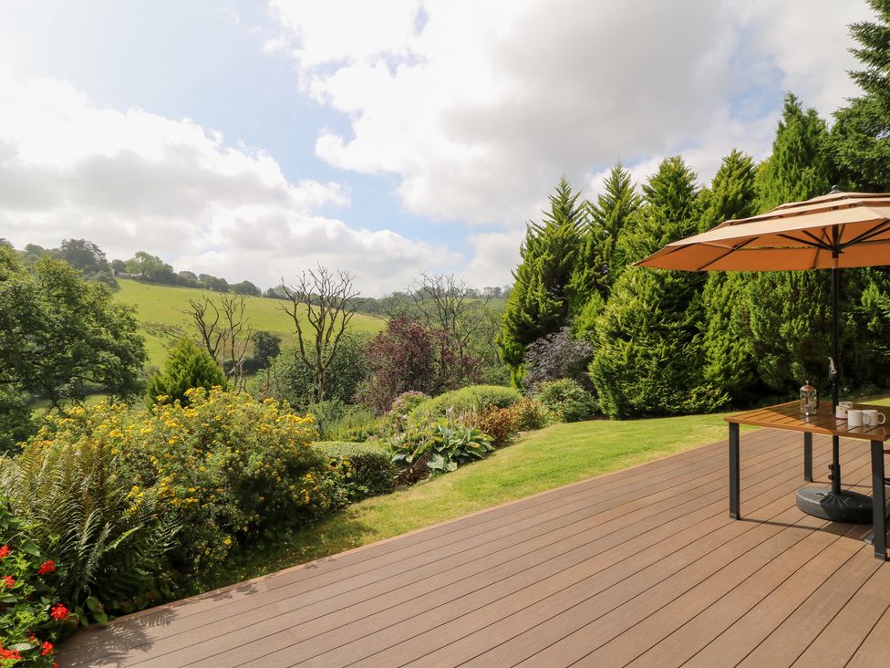 An outdoor area with a table and umbrella at Dan Castell Cottage in Llandeilo, Carmarthenshire