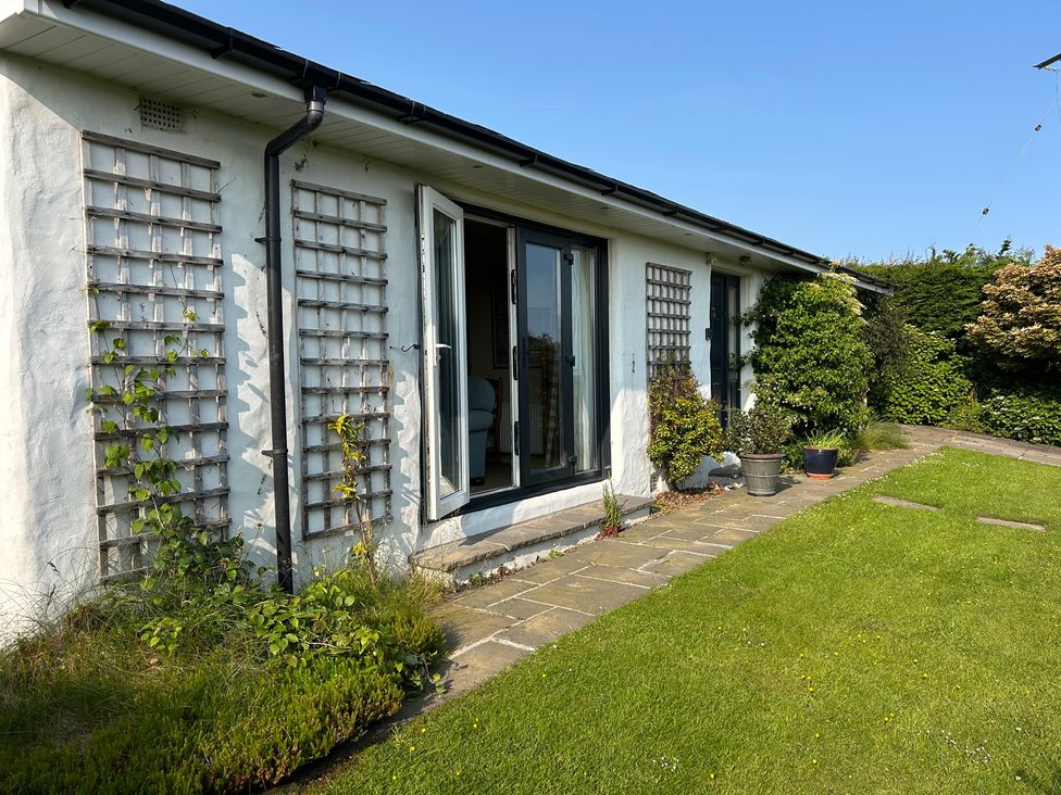 An outdoor view of a house with windows and garden at Dolwylan, Newport, Pembrokeshire