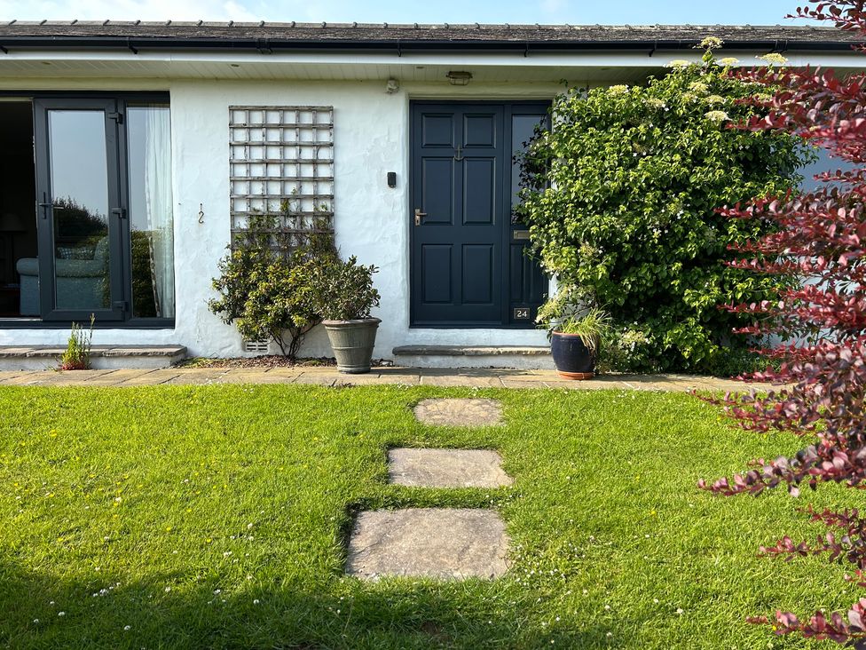 A house entrance with a dark door and pathway at Dolwylan in Newport, Pembrokeshire